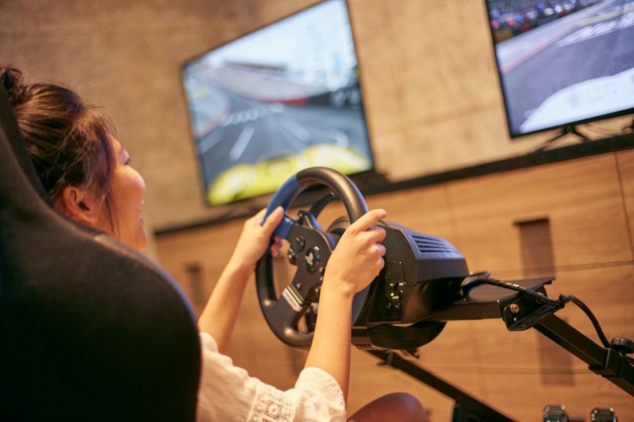 Mu Jiaoxi Hotel Exteriér fotografie A woman playing a racing video game